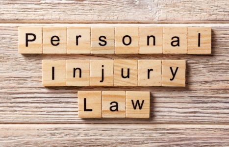 Wooden tiles spell out "Personal Injury Law" on a wood surface.